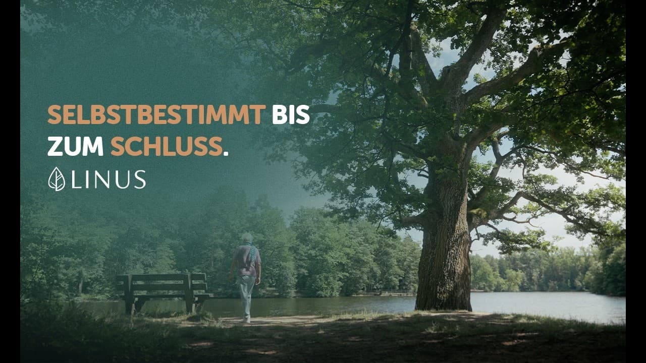 Ein Mann geht auf eine Bank an einem Waldsee zu, daneben eine große Eiche. Eingeblendet: „Selbstbestimmt bis zum Schluss."